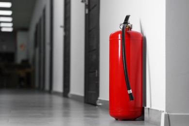 Photo of Fire extinguisher on floor in hall, space for text