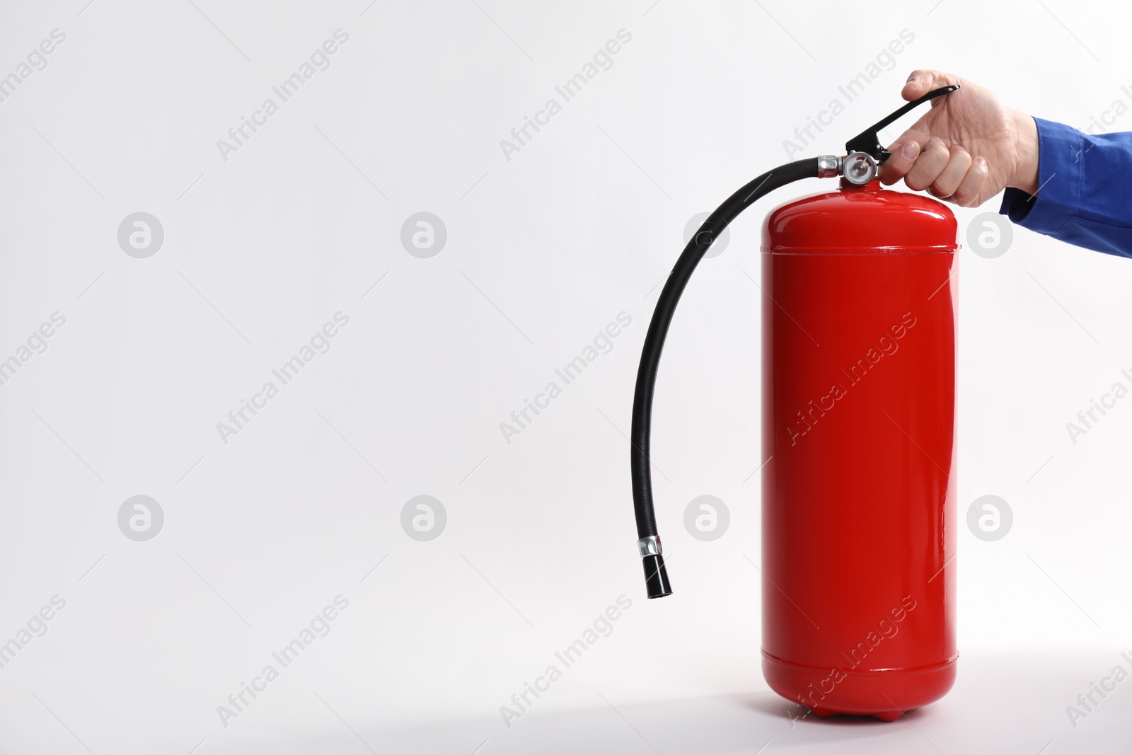 Photo of Man with fire extinguisher on white background, closeup. Space for text