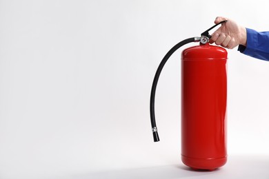 Photo of Man with fire extinguisher on white background, closeup. Space for text