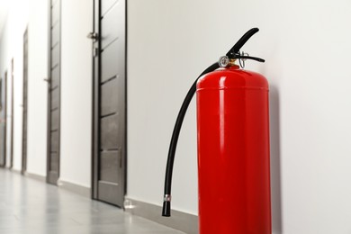 Photo of Fire extinguisher on floor in hall, space for text