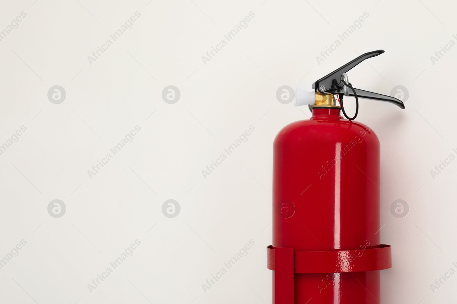 Photo of Fire extinguisher on light background, space for text