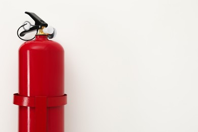 Photo of Fire extinguisher on light background, space for text