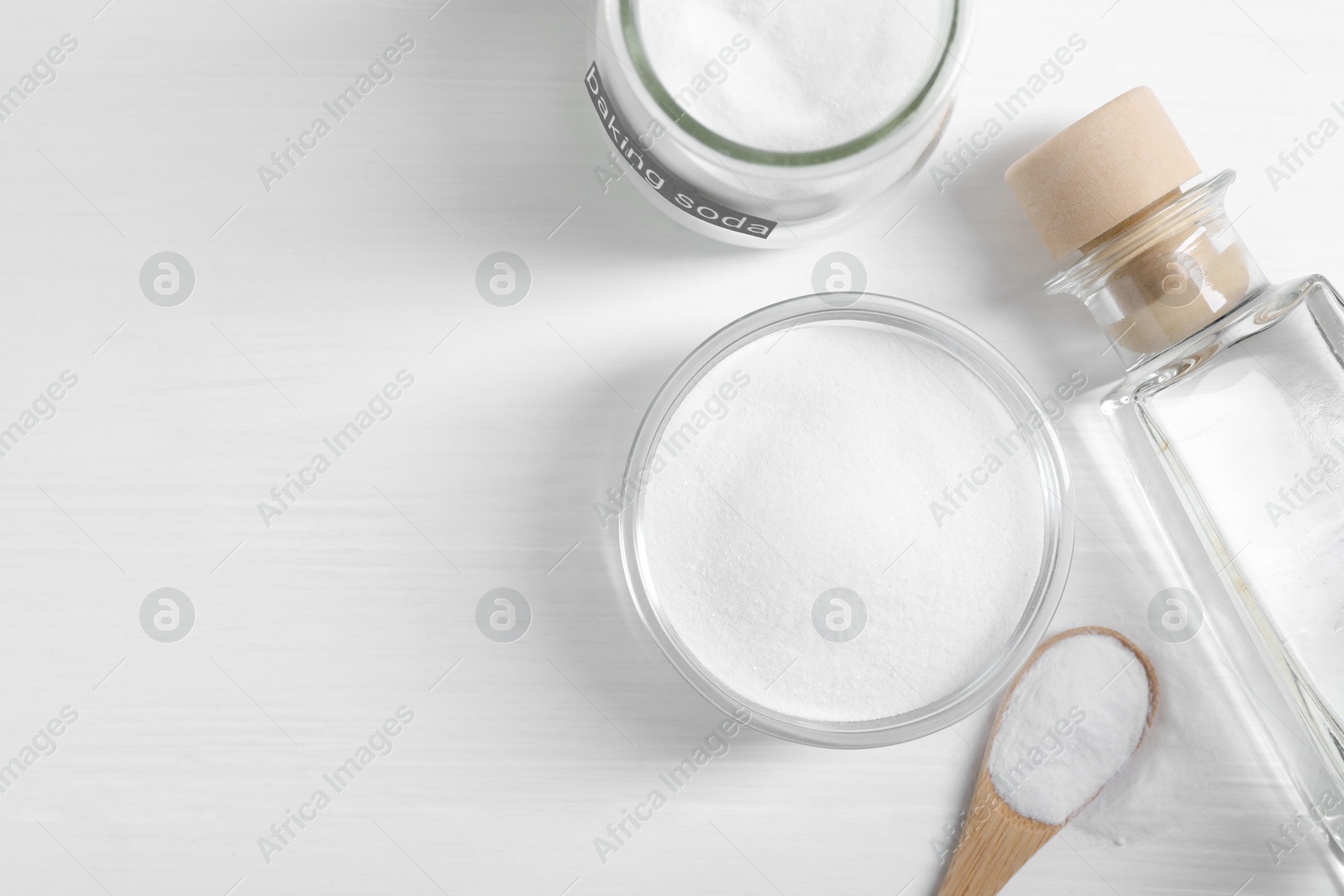 Photo of Baking soda and vinegar on white wooden table, flat lay. Space for text