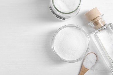 Baking soda and vinegar on white wooden table, flat lay. Space for text