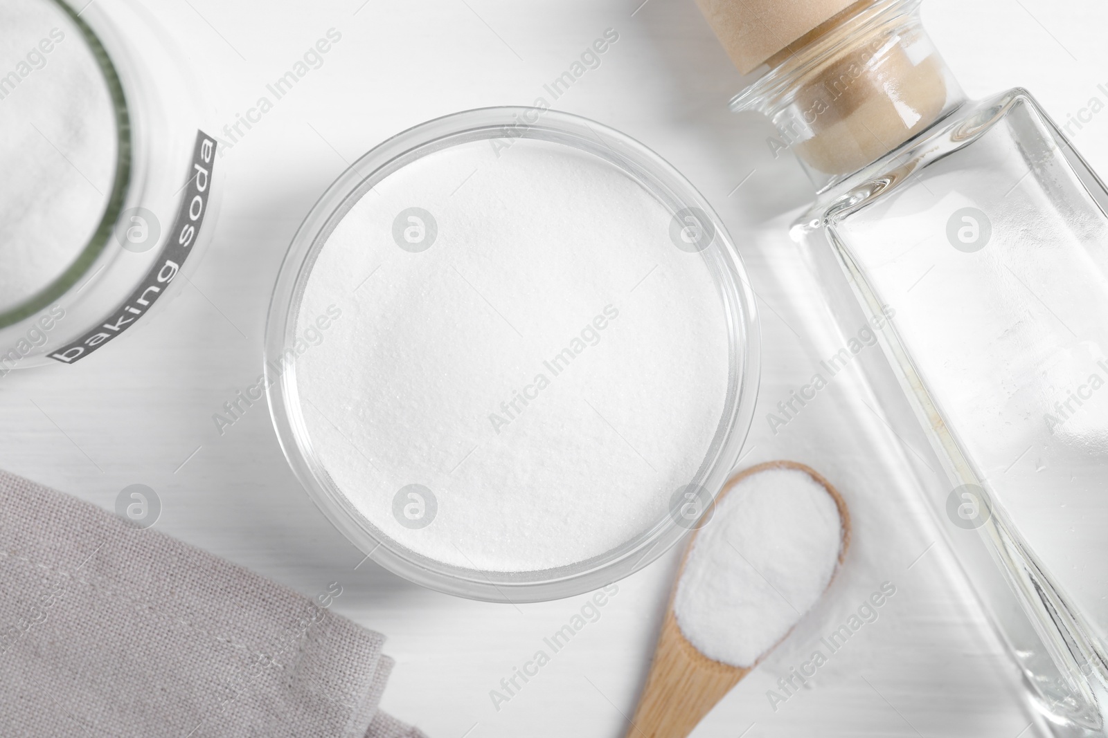 Photo of Baking soda and vinegar on white wooden table, flat lay