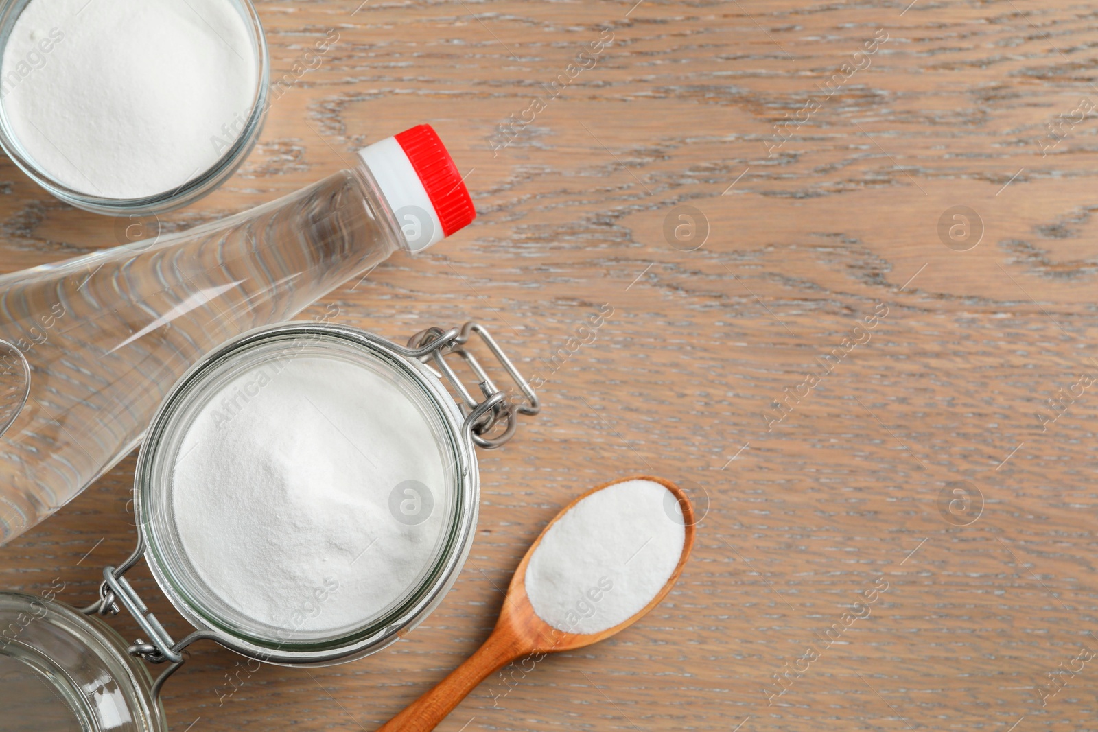 Photo of Baking soda and vinegar on wooden table, flat lay. Space for text