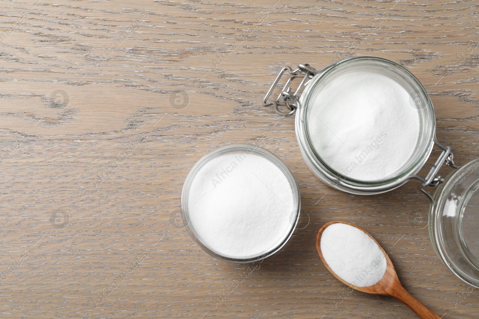 Photo of Baking soda on wooden table, flat lay. Space for text