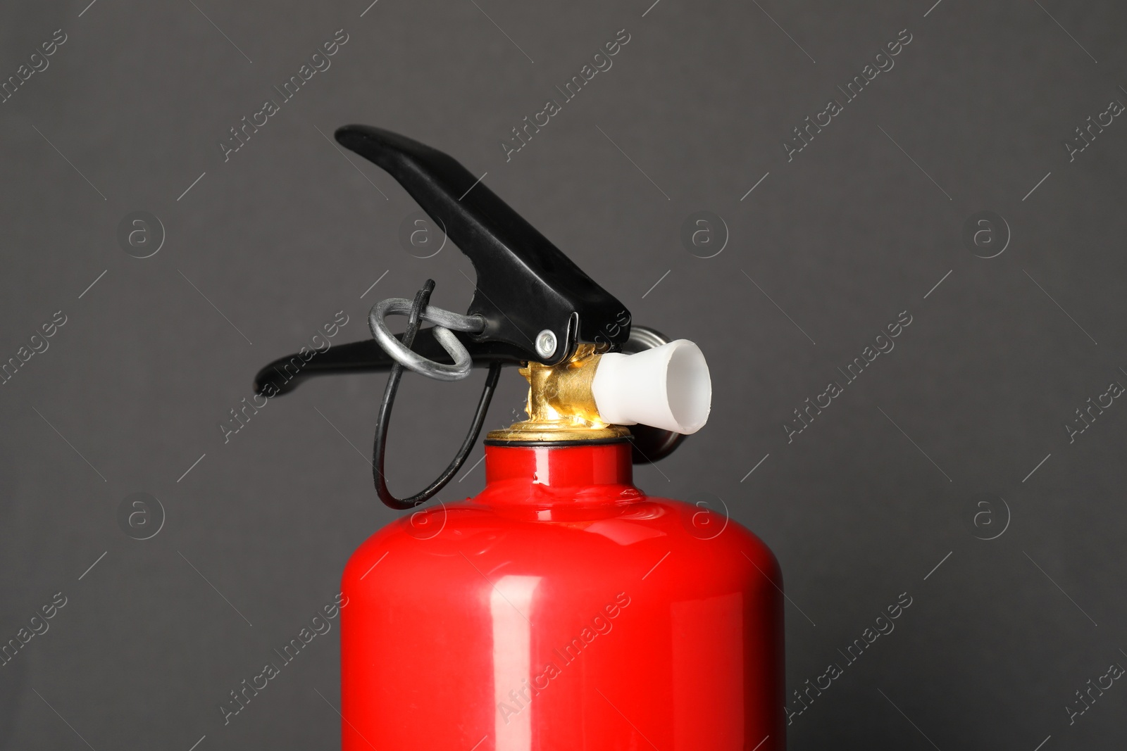 Photo of One red fire extinguisher on dark gray background