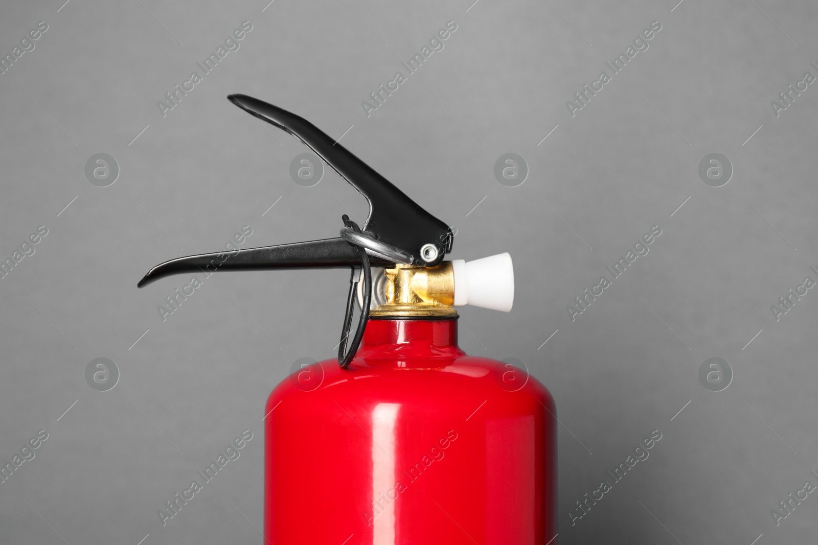 Photo of One red fire extinguisher on gray background