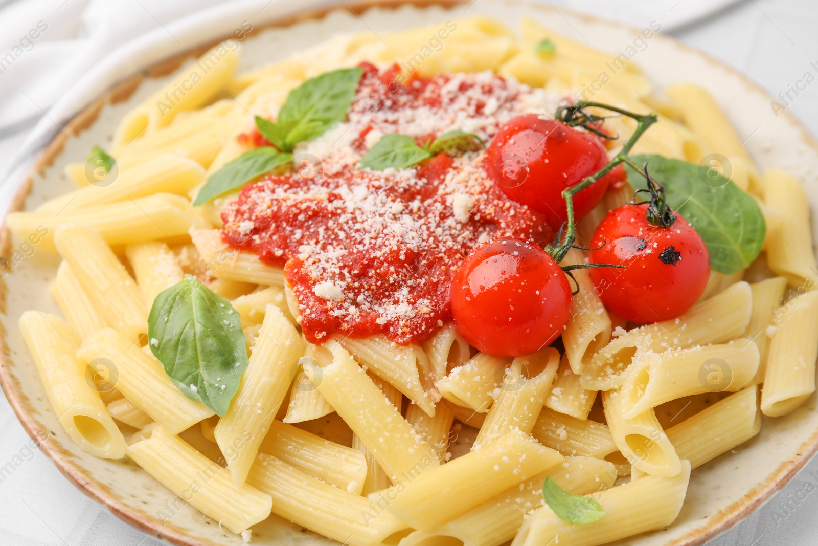 Photo of Tasty pasta with tomato sauce, cheese and basil on table, closeup