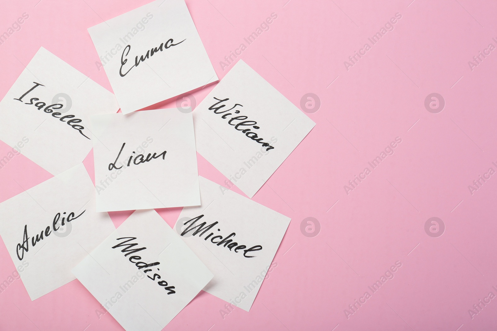Photo of Paper stickers with different names on pink background, flat lay and space for text. Choosing baby's name