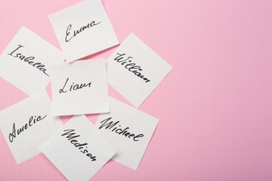 Paper stickers with different names on pink background, flat lay and space for text. Choosing baby's name