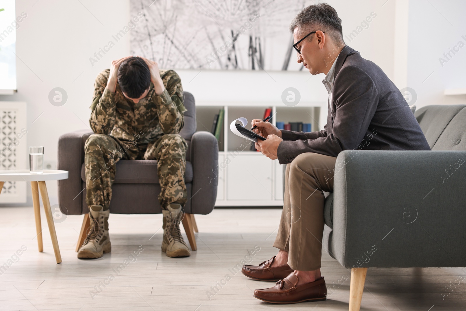 Photo of Professional psychotherapist working with military man in office