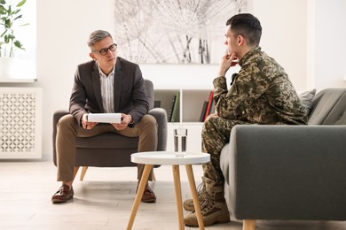 Professional psychotherapist working with military man in office