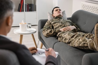 Photo of Professional psychotherapist working with military man in office