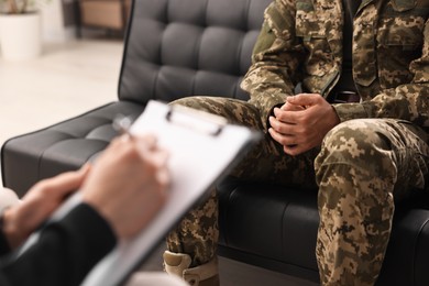 Professional psychotherapist working with military man in office, closeup