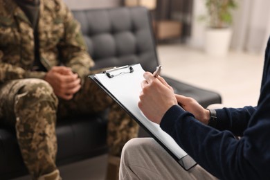 Photo of Professional psychotherapist working with military man in office, closeup