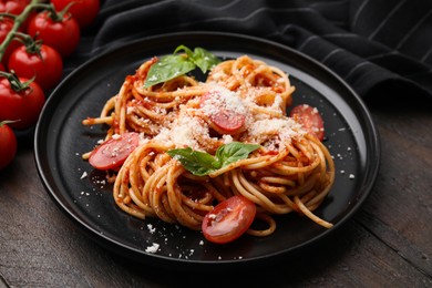 Photo of Tasty pasta with tomato sauce, cheese and basil on wooden table