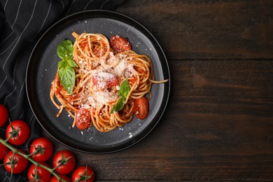 Photo of Tasty pasta with tomato sauce, cheese and basil on wooden table, flat lay. Space for text