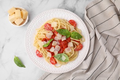 Photo of Tasty pasta with tomato sauce, cheese and basil on white marble table, flat lay