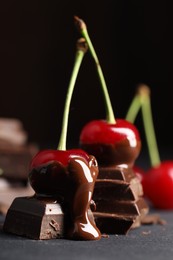 Photo of Fresh cherries with chocolate on grey table, closeup