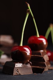 Photo of Fresh cherries with chocolate on grey table, closeup