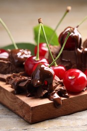 Photo of Fresh cherries with milk chocolate on wooden table, closeup