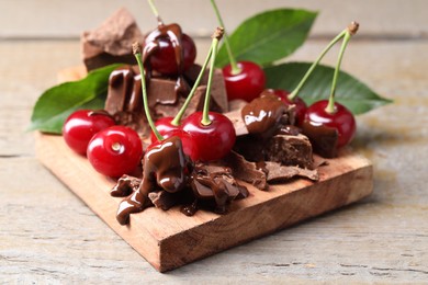 Fresh cherries with milk chocolate on wooden table, closeup