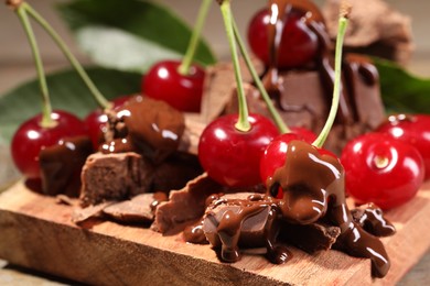 Photo of Fresh cherries with milk chocolate on table, closeup