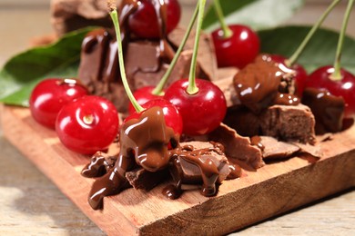 Fresh cherries with milk chocolate on wooden table, closeup