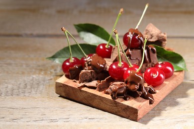 Fresh cherries with milk chocolate on wooden table