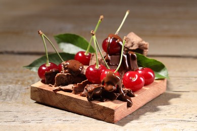 Fresh cherries with milk chocolate on wooden table