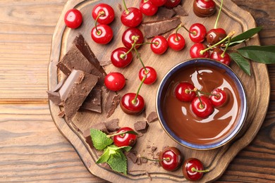 Fresh cherries with chocolate and mint on wooden table, top view