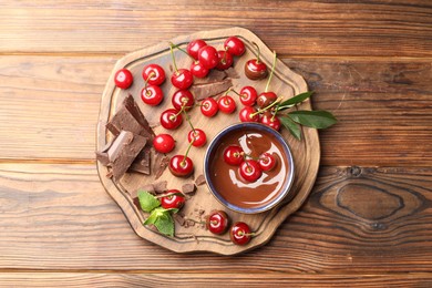 Fresh cherries with chocolate and mint on wooden table, top view