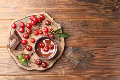 Photo of Fresh cherries with chocolate and mint on wooden table, top view. Space for text