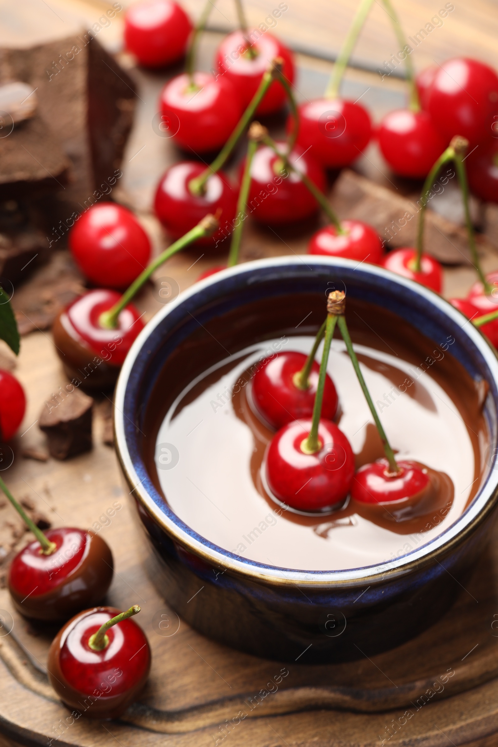 Photo of Fresh cherries with melted chocolate on table, closeup