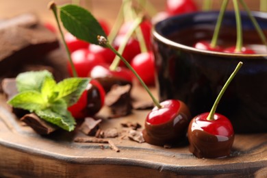 Fresh cherries with melted chocolate and mint on table, closeup