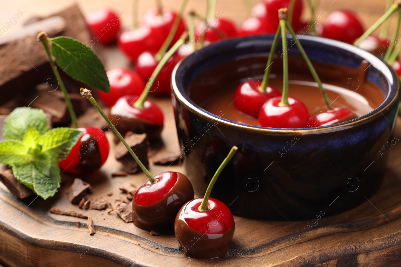 Photo of Fresh cherries with melted chocolate and mint on table, closeup