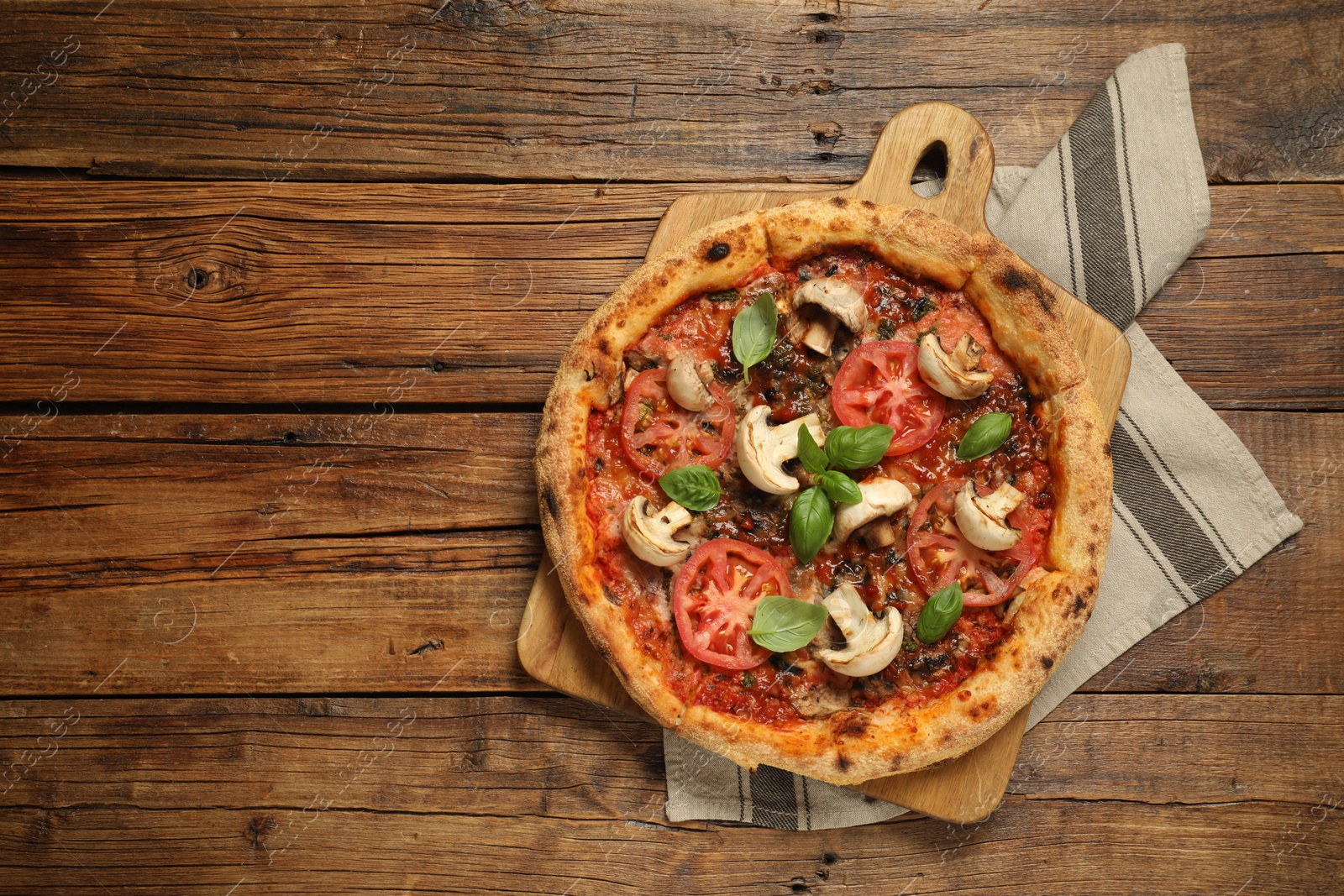 Photo of Tasty pizza with basil, mushrooms and tomato on wooden table, top view. Space for text