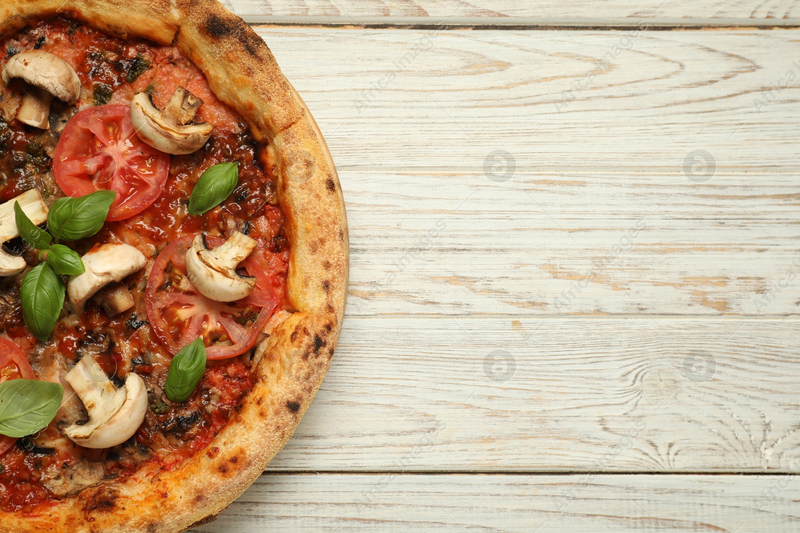 Photo of Tasty pizza with basil, mushrooms and tomato on wooden rustic table, top view. Space for text