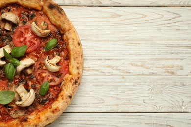 Photo of Tasty pizza with basil, mushrooms and tomato on wooden rustic table, top view. Space for text