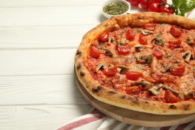 Tasty pizza with mushrooms, herbs and tomato on white wooden table, closeup. Space for text