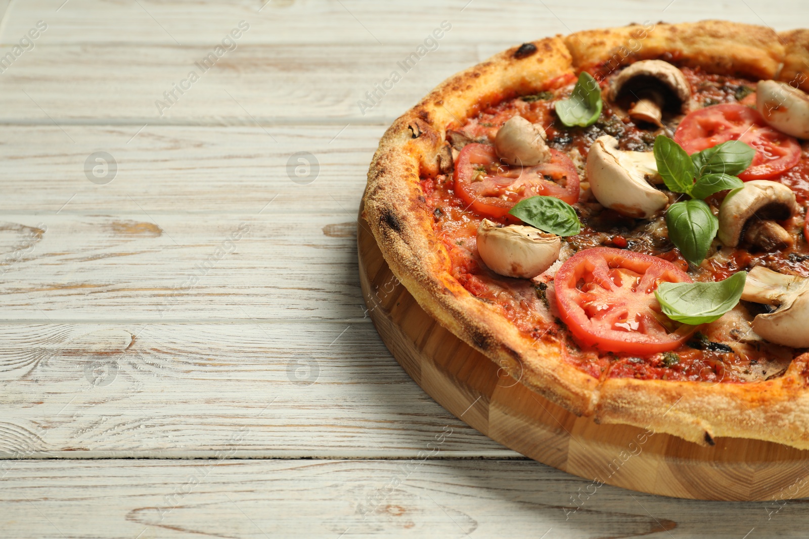 Photo of Tasty pizza with basil, mushrooms and tomato on wooden rustic table, closeup. Space for text