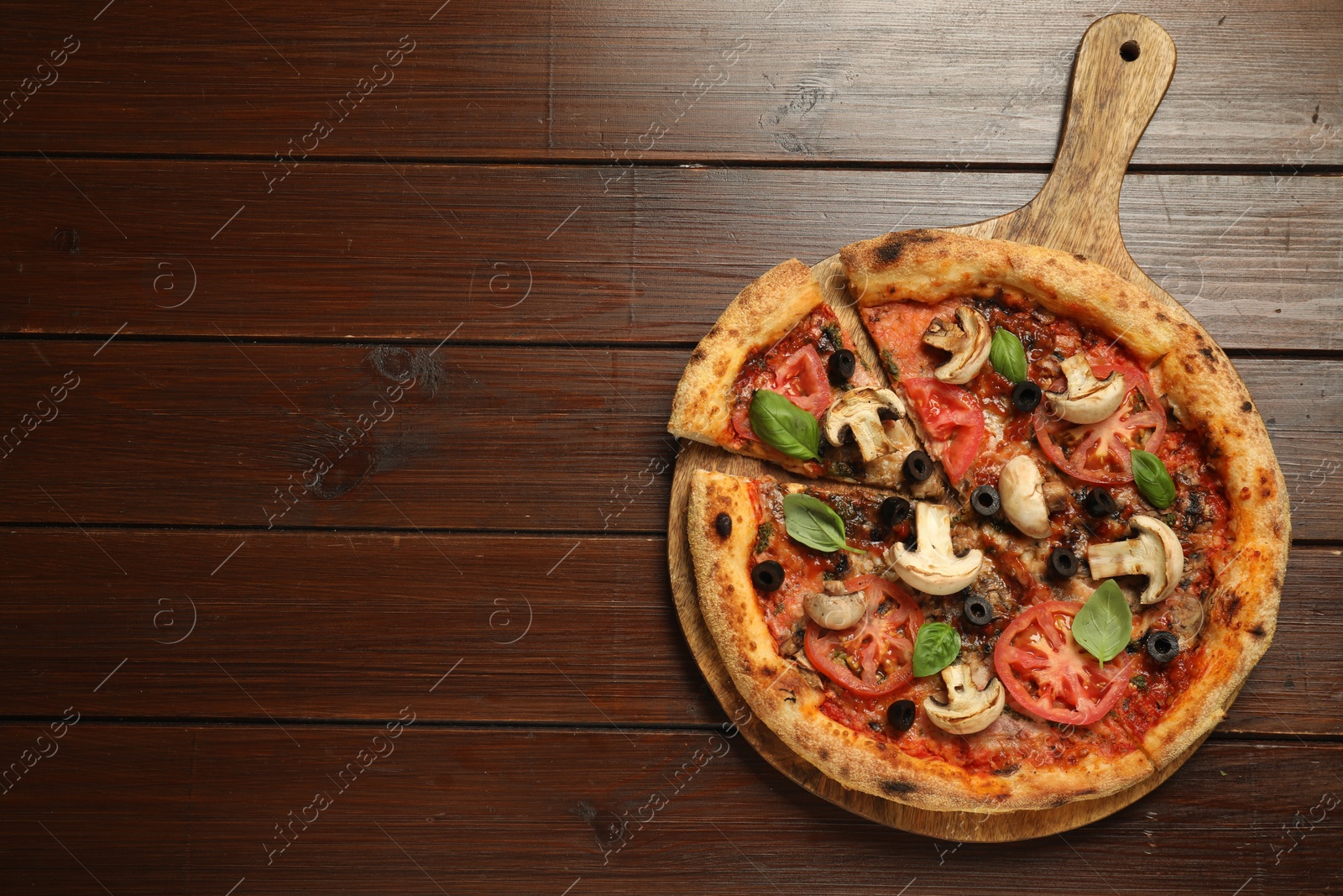 Photo of Tasty pizza with basil, mushrooms, olives and tomato on wooden table, top view. Space for text