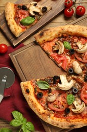 Photo of Tasty pizza with basil, mushroom, olives and tomato on wooden table, flat lay