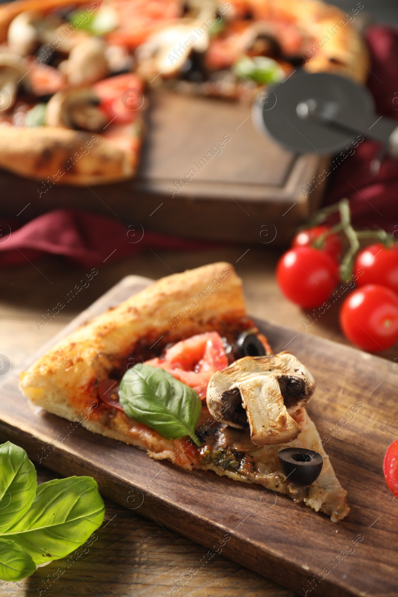 Photo of Piece of tasty pizza with basil, mushroom, olive and tomato on wooden table, closeup