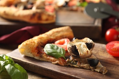 Photo of Piece of tasty pizza with basil, mushroom, olive and tomato on wooden table, closeup