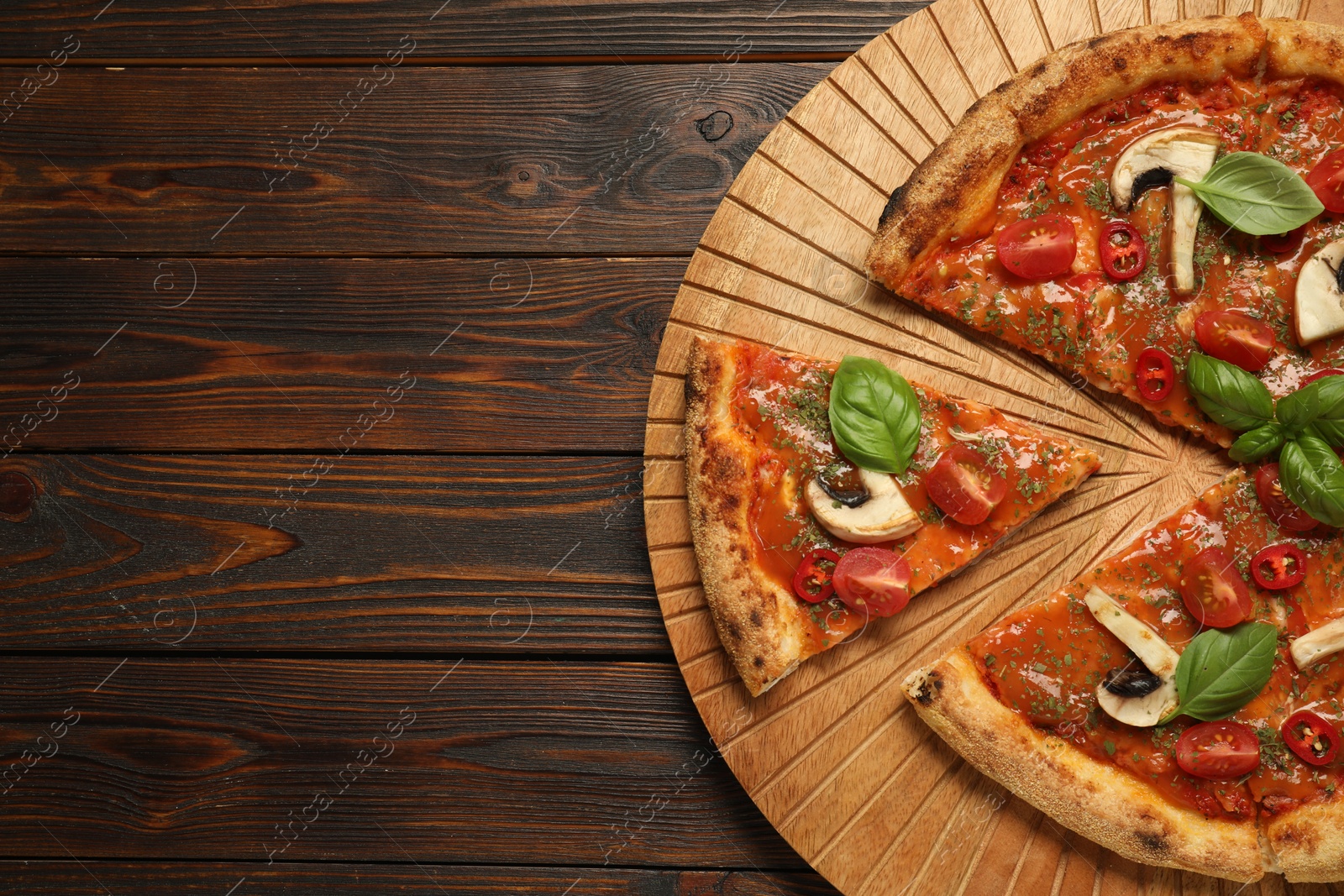 Photo of Tasty pizza with basil, mushrooms, chili pepper and tomato on wooden table, top view. Space for text