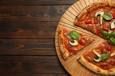 Tasty pizza with basil, mushrooms, chili pepper and tomato on wooden table, top view. Space for text