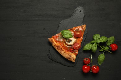 Photo of Piece of tasty pizza with basil, mushroom and tomato on black wooden table, flat lay. Space for text